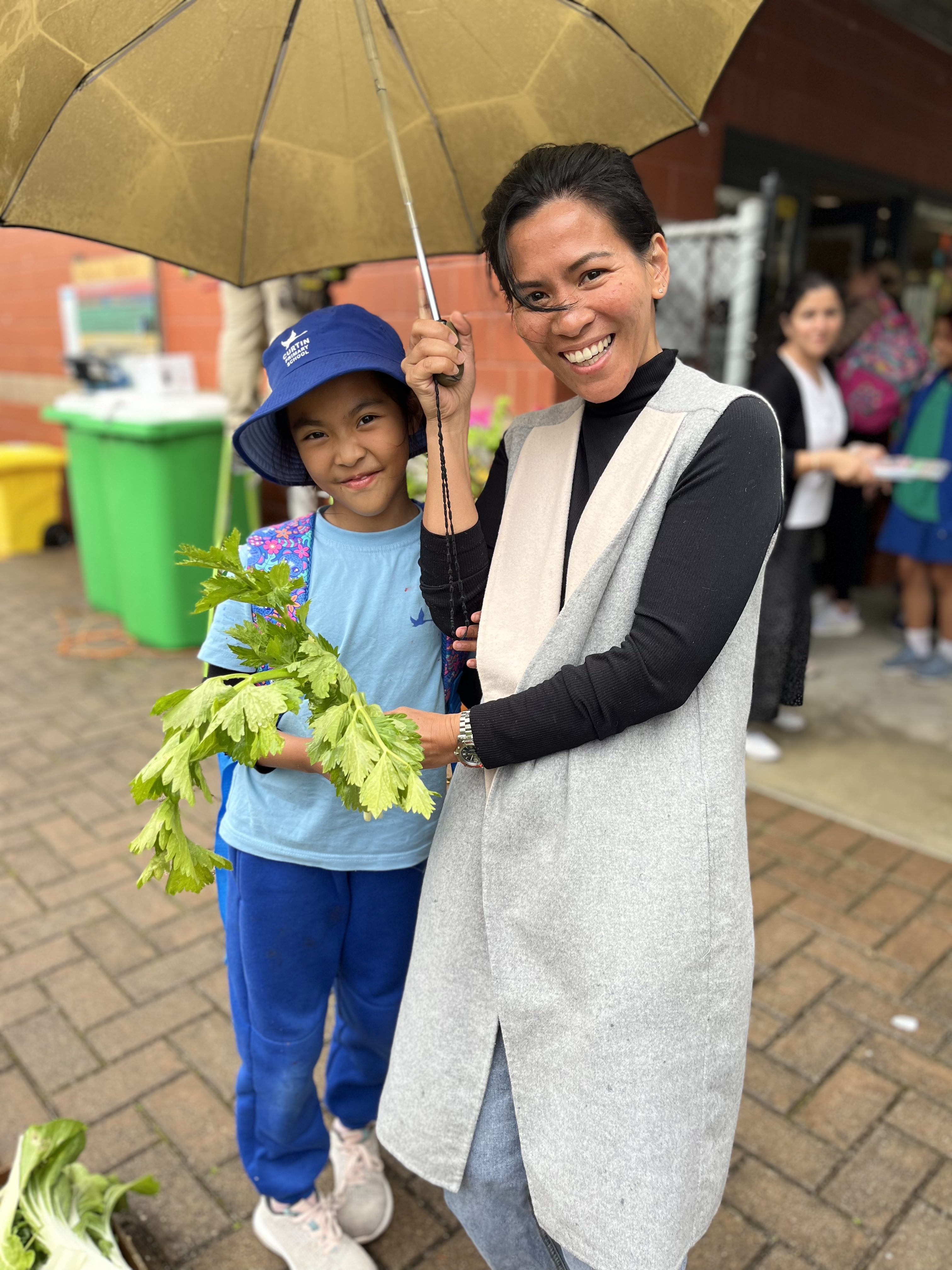 Parent and Student from Curtin Primary School collecting fresh produce from a Harvest Drop Off